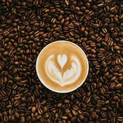 Latte on a table of coffee beans